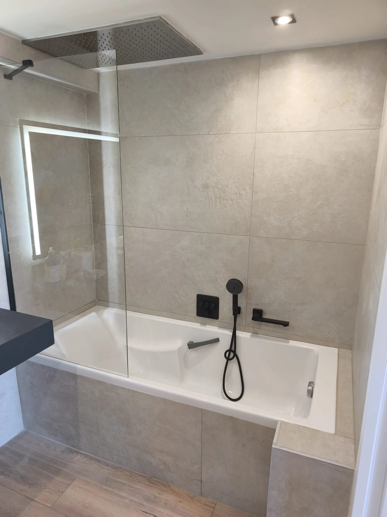 Salle de bain rénovée à Aubagne, carrelage clair et robinetterie noire